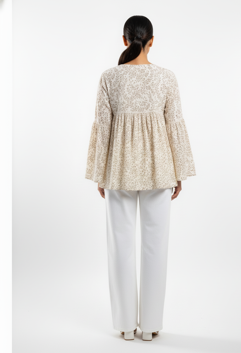 Woman wearing a floral blouse and white pants on a white background
