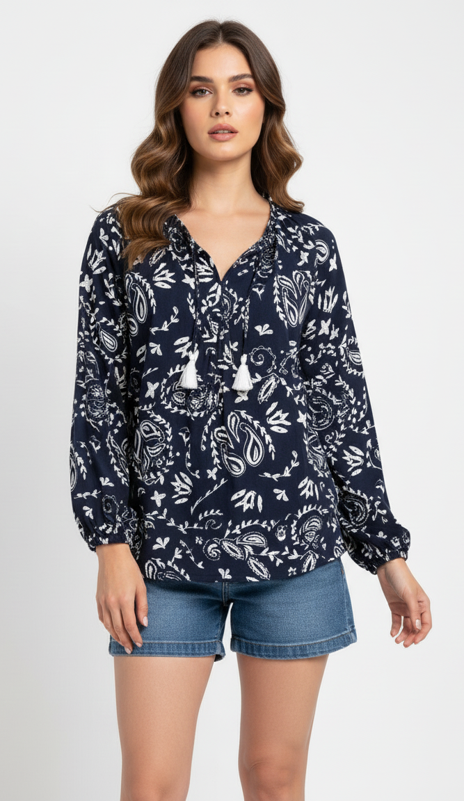 Woman wearing a navy blue floral patterned blouse and denim shorts on a white background
