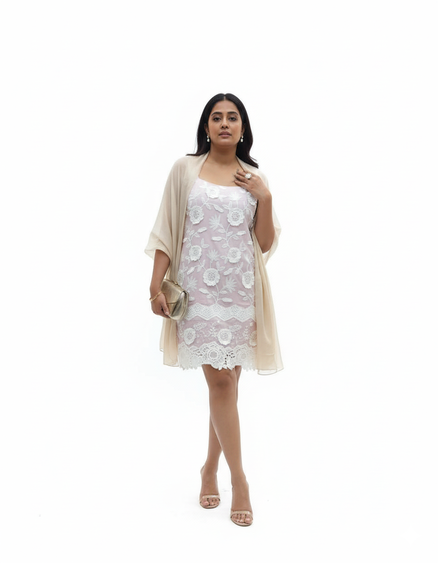 Woman wearing a white lace dress with a beige cardigan on a white background