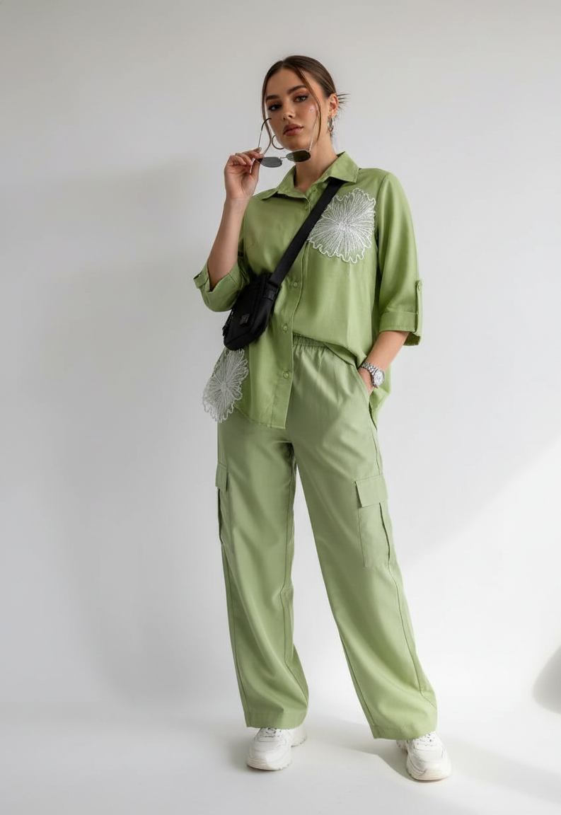 Person wearing a green outfit with lace details on a white background