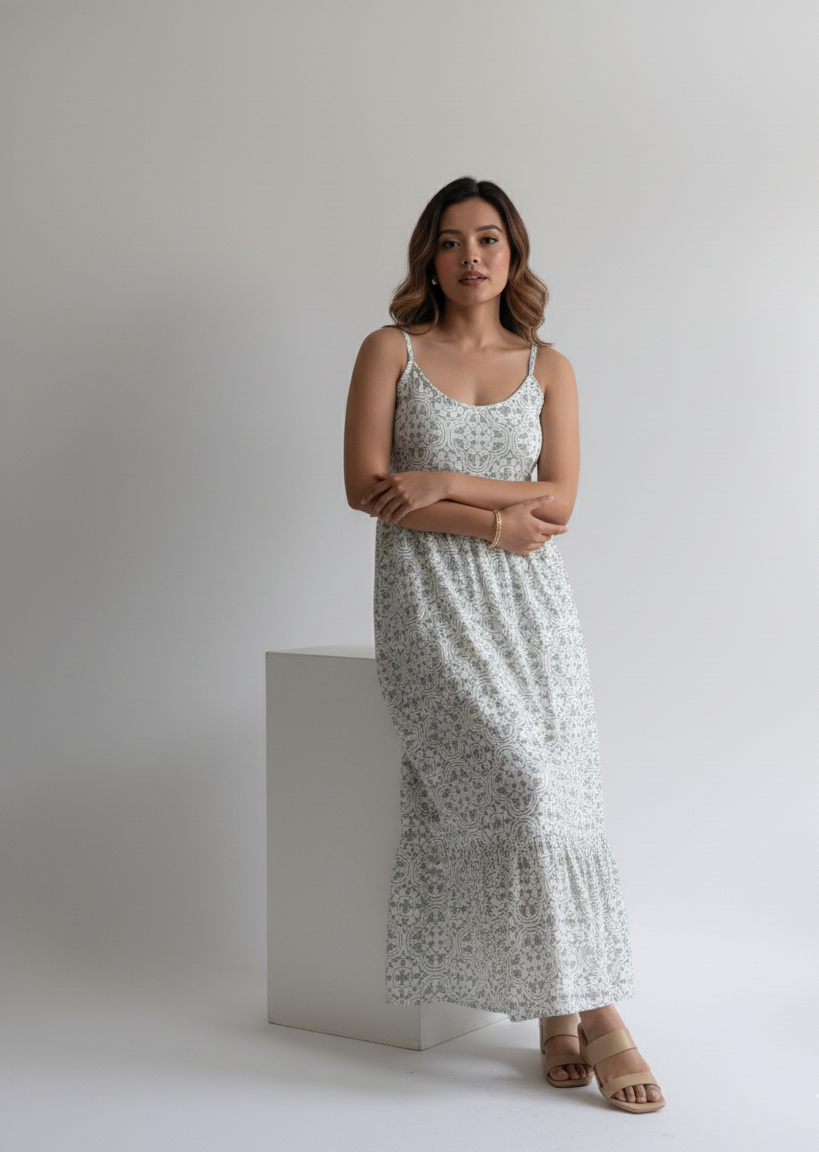 Woman wearing a floral dress standing against a plain background
