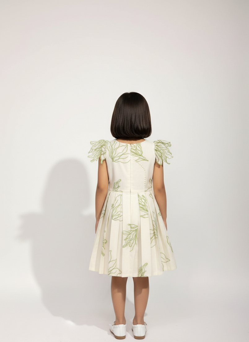 Person wearing a light-colored dress with floral patterns on a white background