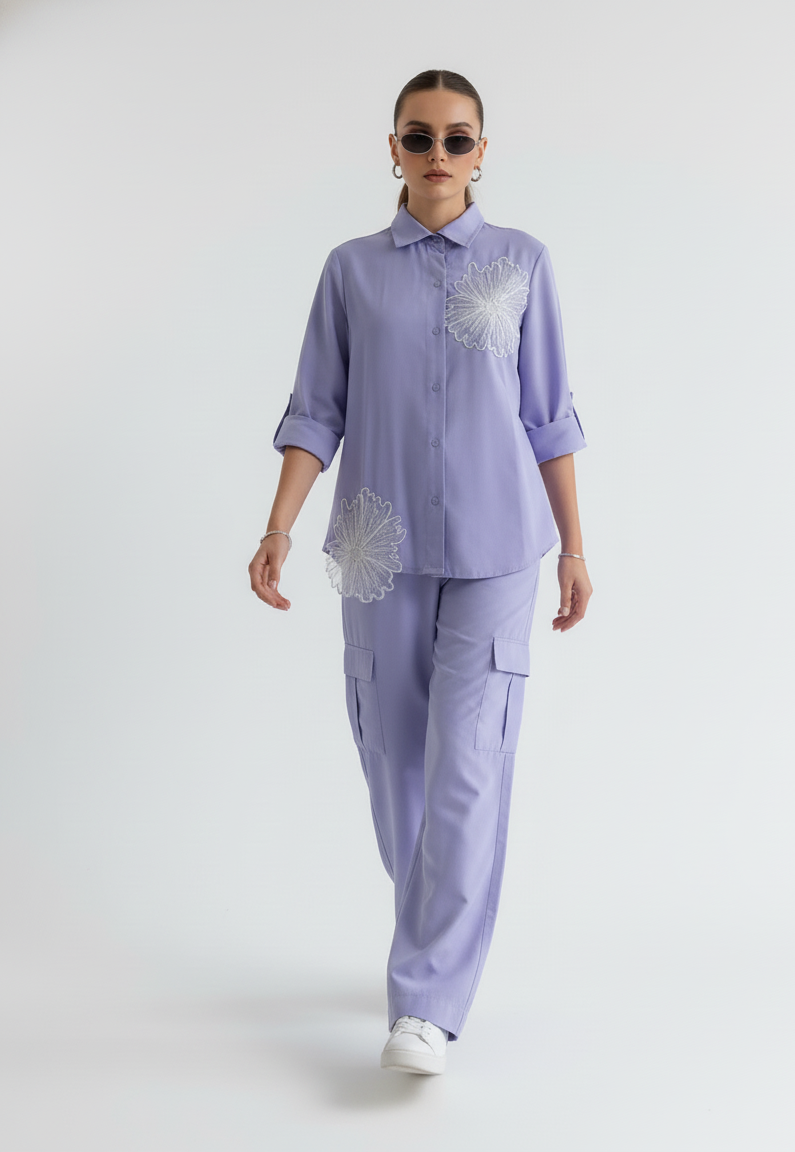 Woman wearing a light purple outfit with floral patterns on a white background