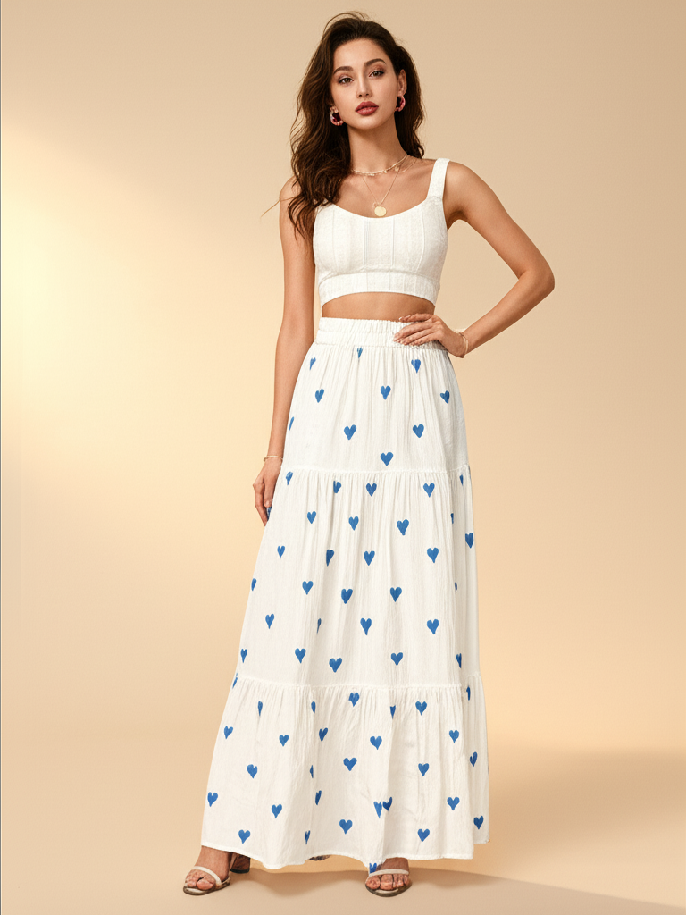Woman wearing a white top and a long white skirt with blue heart patterns on a beige background