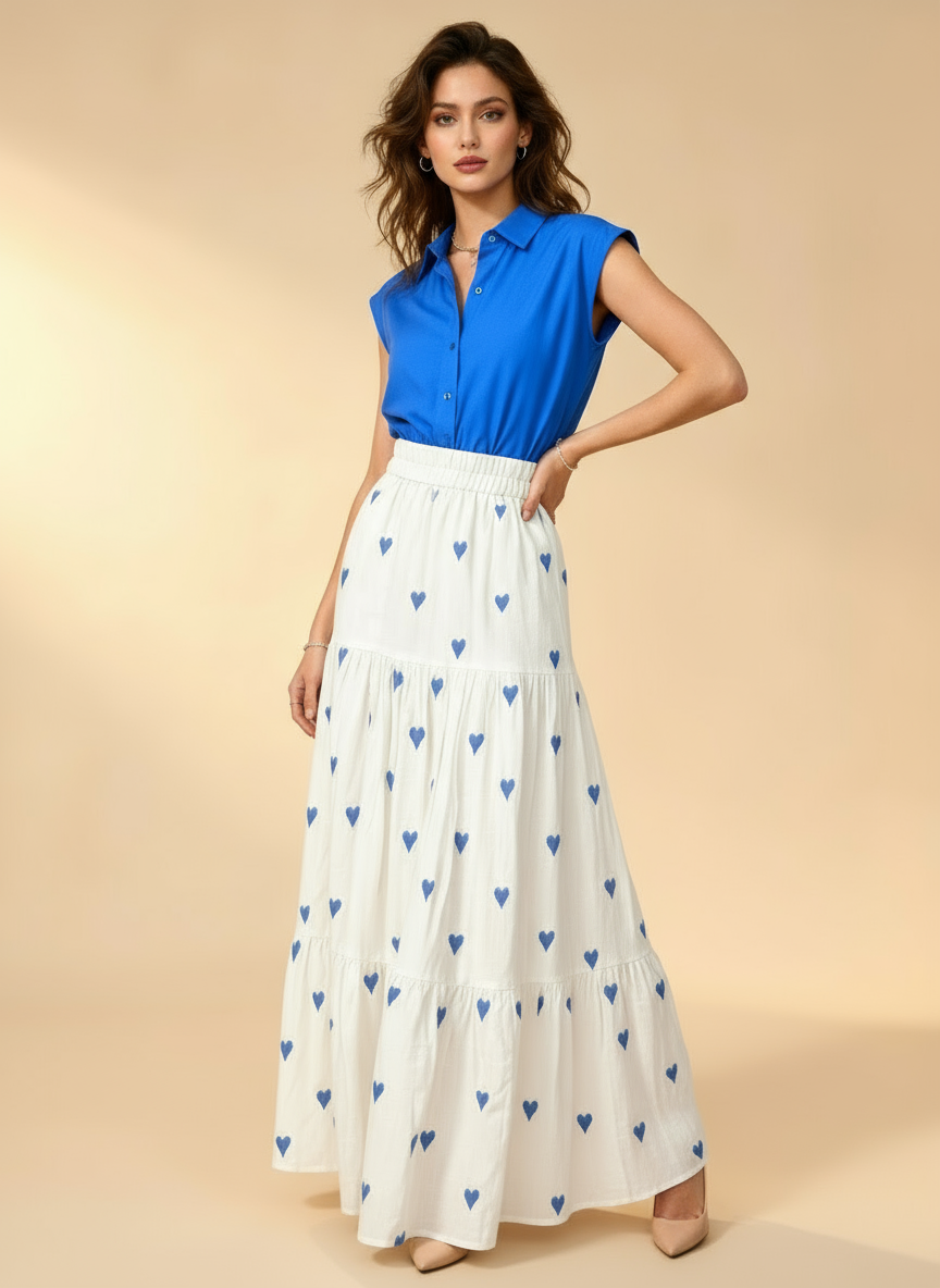 Woman wearing a blue top and white skirt with blue heart patterns on a beige background